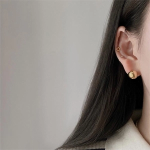 Close-up of model wearing S925 sterling silver golden sphere earrings and floral stud set