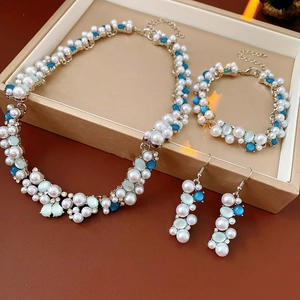 Dettaglio di un set gioielli vintage con perle e gemme turchesi in scatola beige