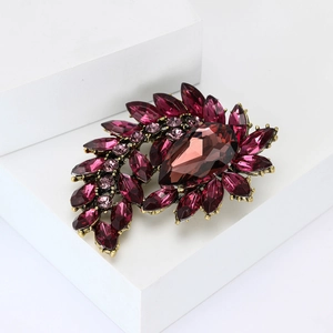 Macro detail of vintage alloy brooch with purple rhinestones and waterdrop gem
