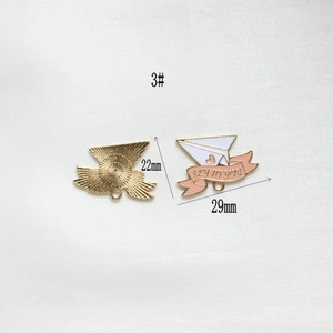 Detail of 29mm gold plane charm with Fly To You text and pink enamel accents