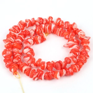 Handmade necklace with irregular red and white shell beads on a subtle yellow cord