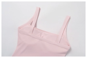 Detail of pink yoga top showing square neckline and smooth fabric texture with pad inserts