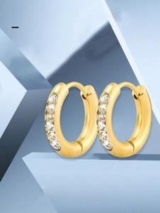 Macro shot of gold-plated titanium steel hoop earrings featuring inlaid cubic zirconia stones