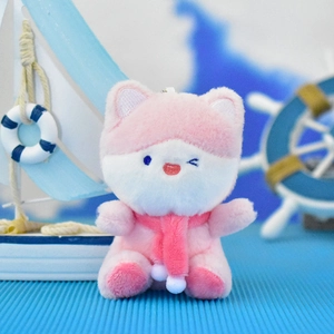 Close-up view of an adorable pink fox plush keychain with nautical background elements