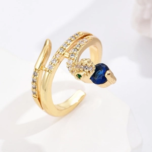 Gold snake ring with blue heart stone and green eyes on white stone base