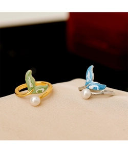 Detailed shot of fish tail rings with freshwater pearls and colorful enamel work