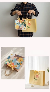 Detailed view of floral gift bags in two sizes with elegant yellow satin bow handles