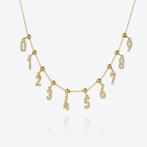 Close-up of gold S925 silver necklace featuring sparkling pavé crystal digit pendants