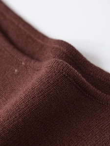 Detailansicht der tiefkaffeebraunen Stricktextur und der hochwertigen Nahtverarbeitung