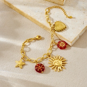 Bracelet doré rétro avec breloques soleil et cœur et perles rouges étoile lune