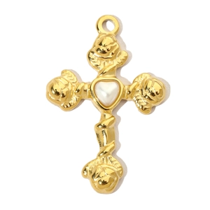 Detail of a golden cross pendant featuring a pearl heart inlay and ornate floral texture