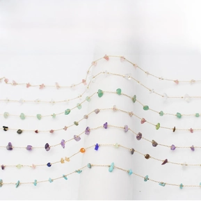 Detailed close-up of golden eyewear chain featuring multi-colored natural crushed stones