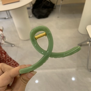 Nahaufnahme der avocadogrünen Haarklammer mit langlebigem goldenem Metallfedermechanismus