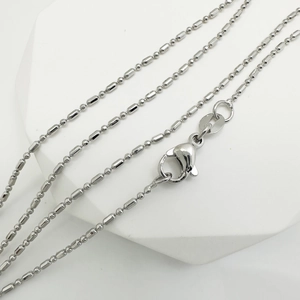 Silver bead chain necklace with 925 silver tag on white geometric display stand