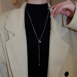 Detailed view of long gold Y-necklace with square zircon and adjustable ball slider