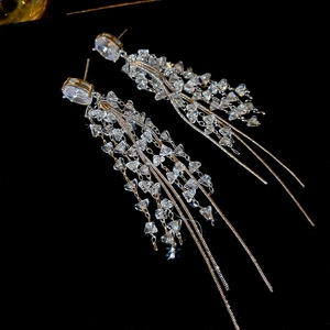 Macro shot of silver tassel earrings with sparkling clear crystals on a black background