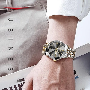 Business quartz men's watch with two-tone steel band and black dial on male wrist