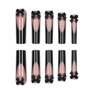 Faux ongles longs avec pointes françaises noires, nœuds 3D et strass brillants