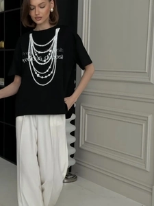 Detail of black cotton T-shirt featuring a pearl necklace print and graphic text design