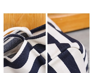 Detailed view of striped canvas bag featuring blue and white texture and drawstring detail