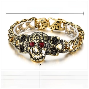 Detail of hip hop skull bracelet featuring red rhinestone eyes and measurement specs