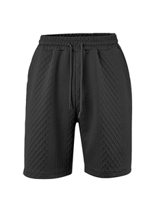 Close-up of black casual shorts featuring textured geometric fabric and drawstring waist