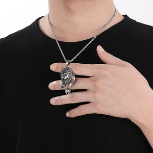 Detail of punk stainless steel lion head pendant with red eyes on twisted rope chain