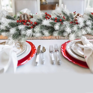 180cm flocked Christmas garland with red berries and gold ornaments on a dining table