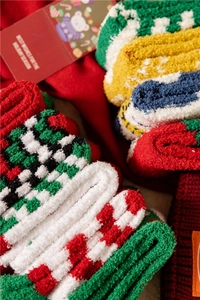 Detailed view of colorful Christmas coral fleece socks with festive patterns and gift card