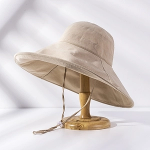 Close-up of beige wide brim sun hat fabric texture and adjustable windproof cord