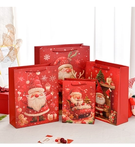 Detail of four red Santa Claus gift bags with sturdy handles and festive illustrations