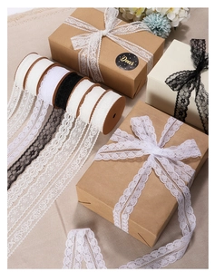 Detail of white and black lace ribbon rolls on gift boxes for wedding packaging