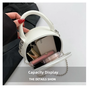 Detail showing the internal storage capacity of the white circular handbag with silver chain