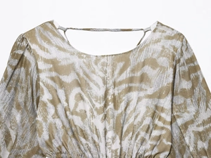 Detalle de vestido estampado con motivos de cebra y detalles de cordón en la cintura