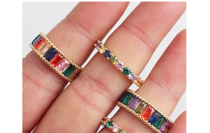 Close-up of gold rainbow ring featuring colorful rectangular and round cut crystals
