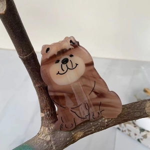 Macro view of a cute cartoon otter hair claw clip made of brown acetate marble finish