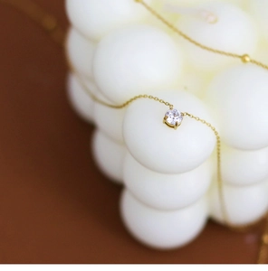 Detailed close-up of a 18K gold plated necklace featuring a 4-prong set cubic zirconia