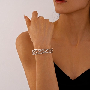 Detailed view of silver mesh textured twisted bangle with geometric hollow design