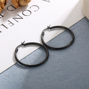 Detailed view of matte black oversized round hoop earrings on a decorative white card