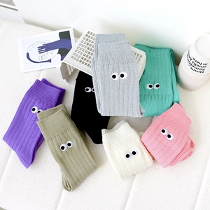Detailed flat lay of knit socks with eye embroidery in various candy colors