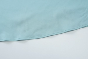 Nahaufnahme von hellblauem Satin-Kleidsaum mit Seidentextur und feiner Verarbeitung