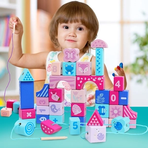 Toddler playing with wooden blocks featuring numbers and animal patterns for motor skills