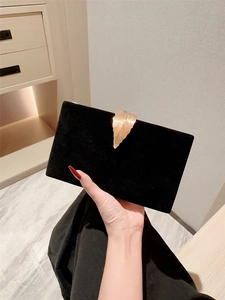 Elegant black velvet evening clutch bag featuring a gold feather-shaped metal clasp buckle