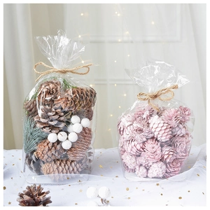Detail of pink and natural pine cones in gift bags with twine bows and sequin fabric