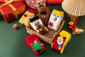 Close-up of thick coral fleece Christmas socks featuring festive 3D embroidery details