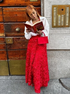 Detailed close-up of vibrant red 3D petal texture on an elegant long evening skirt