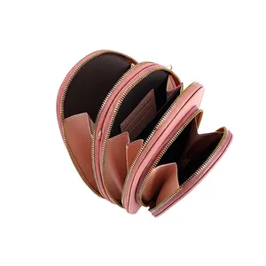 Pink leather crossbody phone bag with three zipper compartments and card slots