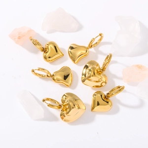 Polished hollow heart-shaped gold-plated stainless steel earrings on white background