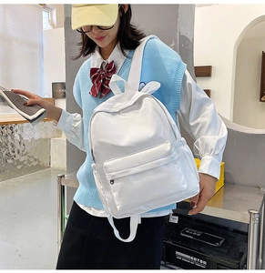 Detailed back view of a white rabbit-ear school backpack worn by a female model in school uniform