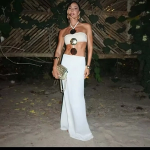 Elegant white two-piece beach dress featuring golden metal discs and a slim maxi skirt